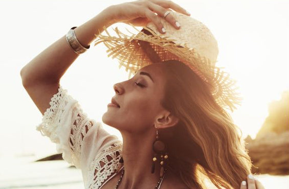 Woman wearing straw hat with an amazing spray tan enjoying a beautiful day at the beach